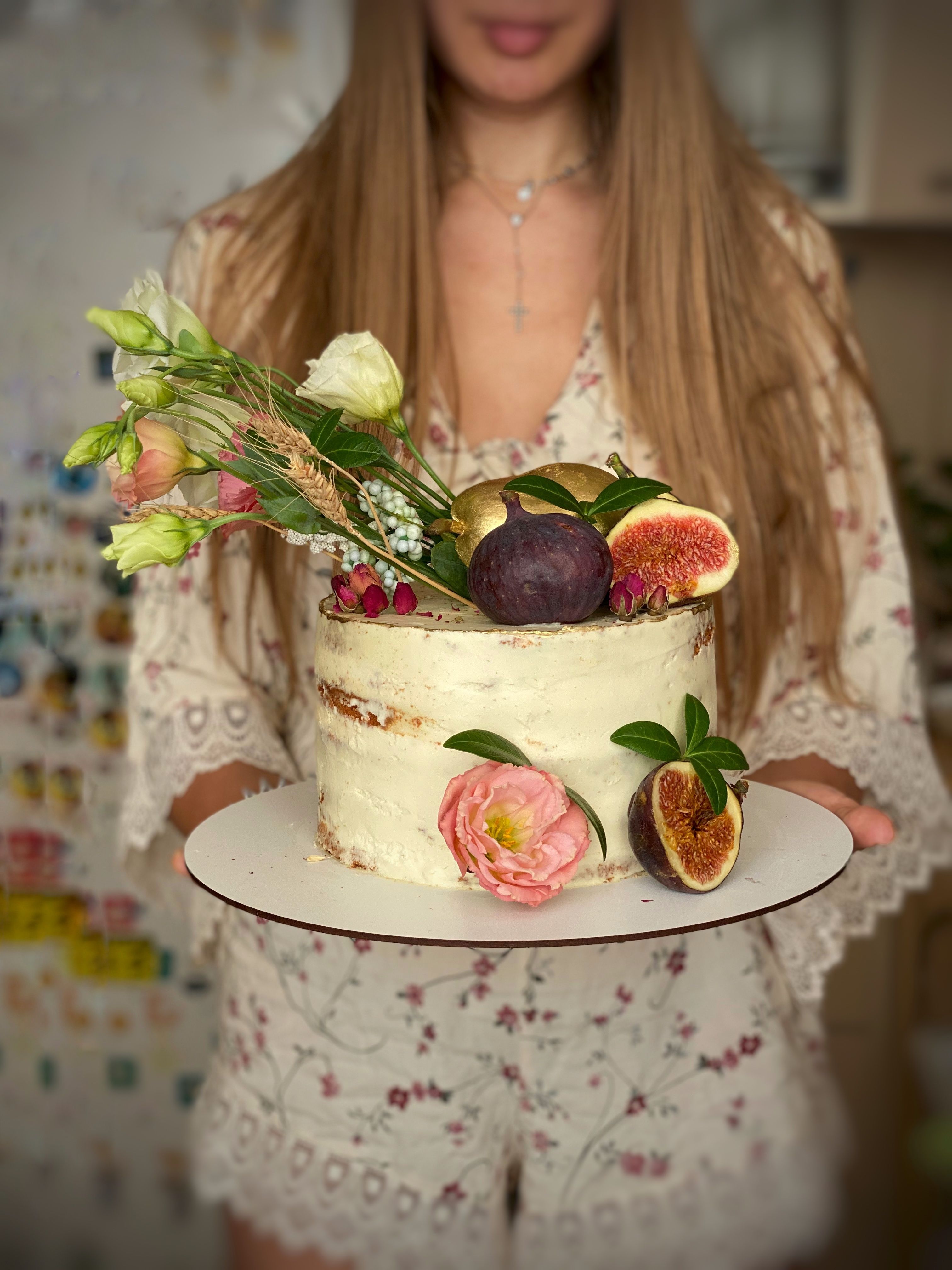 Maryna holding a cake with figs and fresh flowers